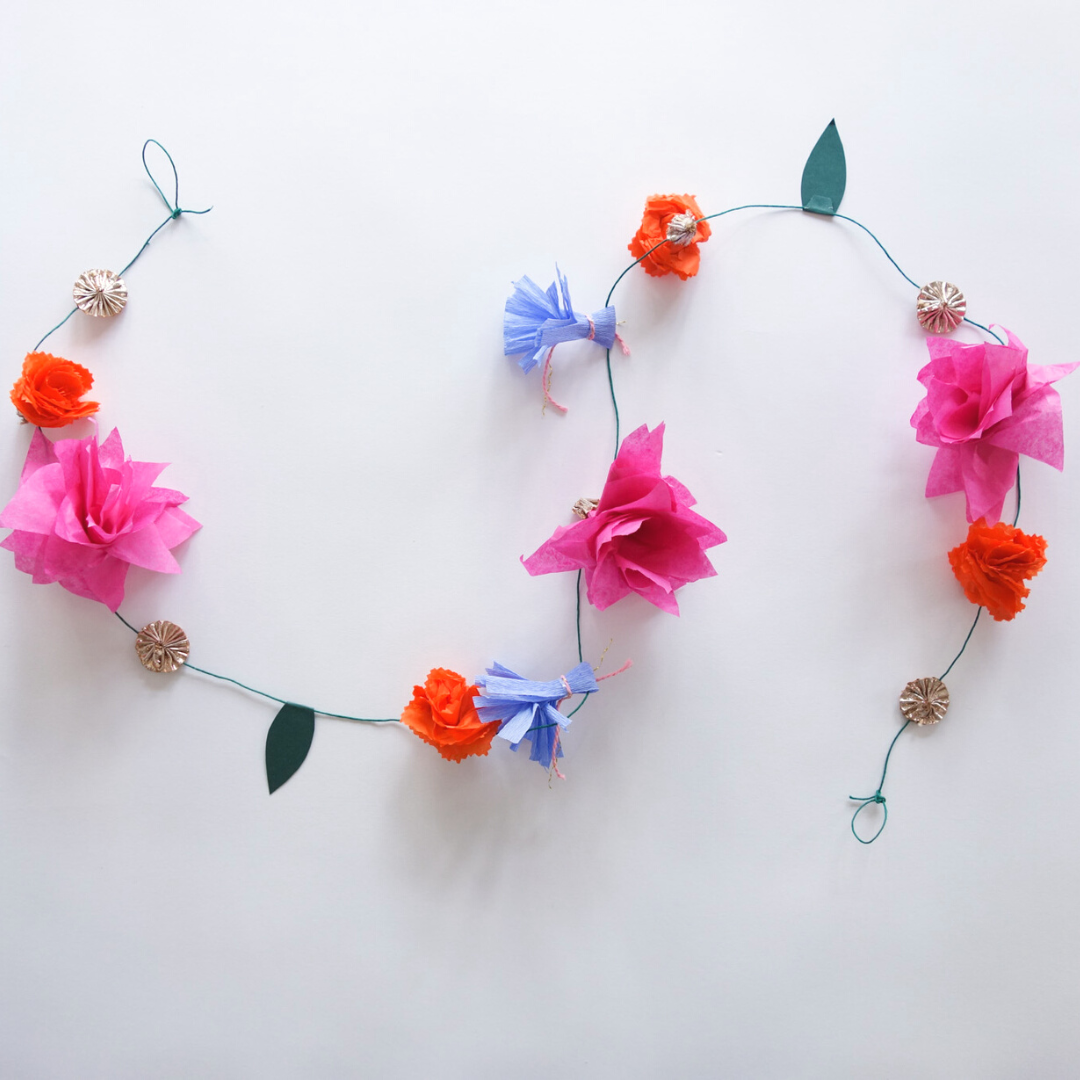 Flatlay of Lotus Garland in pink, orange, periwinkle, and green