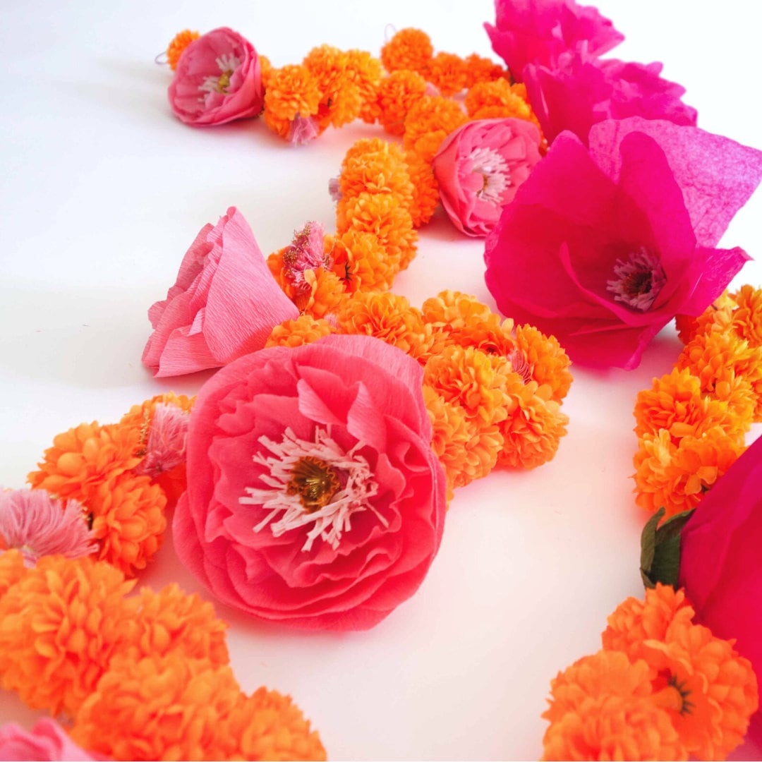 Close up view of marigold garlands with pink peony flower and fuchsia garland