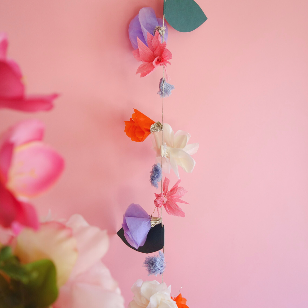 Close up of Flora Garland hanging on pink backdrop