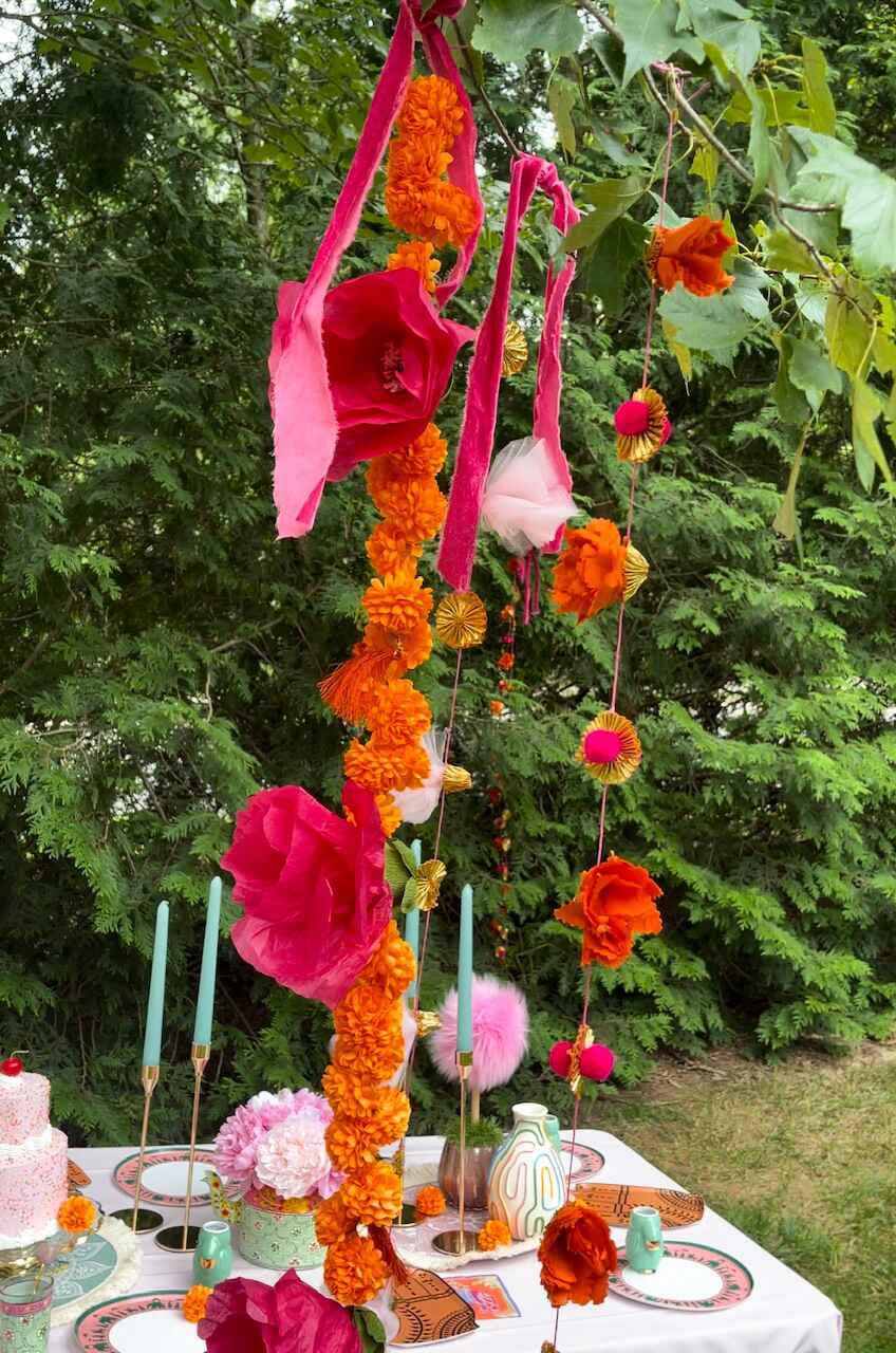 Marigold garland paired with other garlands hanging from trees